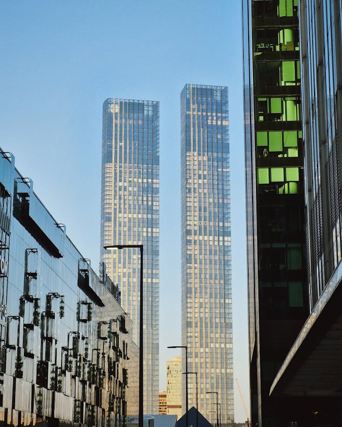 Twin skyscrapers reflecting modern city architecture in a serene morning scene.